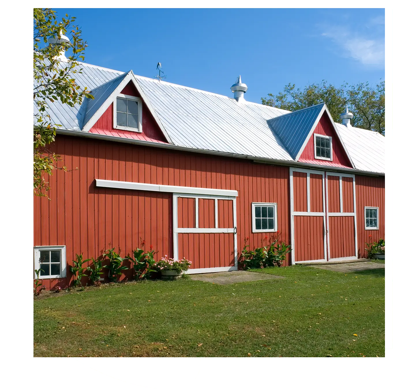 Red barn with metal roof and doors.